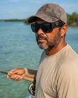 Man, 44, wearing Peppers Big Kahuna sunglasses in Matte Black Frame with Smoke Lens, on a flats boat in shallow turquoise water