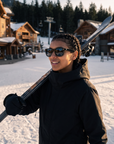 Woman, 26, wearing Peppers Chilmark sunglasses in Shiny Black Frame with Smoke Lens, in a ski village after the lifts close