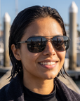 Woman, 25, wearing Peppers Defender sunglasses in Matte Black Frame with Smoke Lens, on a harbour dock after a dive