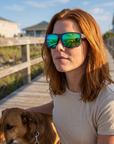 Woman, 31, wearing Peppers Gambler sunglasses in Grey Woody Demi Frame with Brown Emerald Green Mirror Lens, on a beach boardwalk
