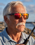 Man, 61, wearing Peppers Grand Teton sunglasses in Matte Black Frame with Red Mirror Lens, on a river-mouth jetty