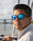 Man, 40, wearing Peppers Islander sunglasses in Matte Black to Tort Frame with Blue Diamond Mirror Lens, at a shallow inlet