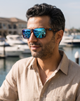 Man, 41, wearing Peppers Low Rider sunglasses in Matte Tort Frame with Blue Revo Lens, on a waterfront yacht-club terrace