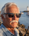 Man, 61, wearing Peppers Low Rider sunglasses in Matte Grey Gradient Crystal Frame with Smoke Lens, on a river-mouth jetty