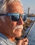 Man, 61, wearing Peppers Mountain Madness sunglasses in Matte Crystal Blue to Black Frame with Blue Diamond Mirror Lens, on a river-mouth jetty