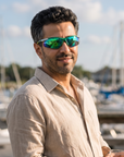 Man, 41, wearing Peppers Ricochet sunglasses in Shiny Green / Silver Frame with Green Diamond Mirror Lens, on a waterfront yacht-club terrace