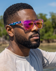 Man, 31, wearing Peppers Sailfish sunglasses in Shiny Pink with Blue Pattern Temples with Pink Mirror Lens, on the flats