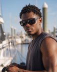 Man, 26, wearing Peppers Sea Dweller 2.0 sunglasses in Matte Black Frame with Smoke Lens, at a busy marina