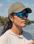 Woman, 40, wearing Peppers Three Wood sunglasses in Matte Black Frame with Blue Revo PC Lens, on the flats
