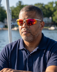 Man, 49, wearing Peppers Three Wood sunglasses in Matte White Frame with Red Revo PC Lens, on a lake