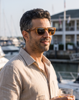 Man, 41, wearing Peppers Chilmark sunglasses in Caramel Frame with Brown Lens, on a waterfront yacht-club terrace