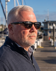 Man, 54, wearing Peppers Chilmark sunglasses in Shiny Black to Tort Frame with Smoke Lens, on a marina walkway