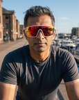 Man, 43, wearing Peppers Cool Driver sunglasses in Matte White Frame with Red Revo PC Lens, on a waterfront bike path