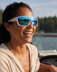 Woman, 33, wearing Peppers Enzo sunglasses in Shiny White Frame with Blue Diamond Mirror Lens, on a lake
