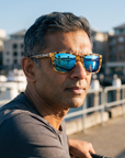 Man, 43, wearing Peppers Gaucho sunglasses in Japanese Yellow Demi Frame with Brown Diamond Blue Mirror Lens, on a waterfront bike path