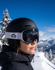 Woman, 23, wearing Peppers Glade Runner Pro goggles in Shiny White with Smoke, on the slope above the base area