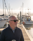 Man, 54, wearing Peppers Mermaid sunglasses in Shiny Black to Honey Tort Frame with Brown Lens, on a misty marina walkway