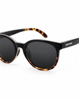 Peppers Mermaid sunglasses in Shiny Black to Honey Tort with Brown lens, three-quarter view on white