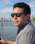 Man, 40, wearing Peppers Milano sunglasses in Shiny Black to Shiny Tort Frame with G15 Lens, at a shallow inlet
