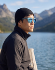 Man, 33, wearing Peppers Sweetwater sunglasses in Dove Grey Frame with Light Blue Mirror Lens, on a mountain lake dock