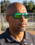 Man, 38, wearing Peppers Whaler sunglasses in Dark Gunmetal Frame with Green Diamond Mirror Lens, at an empty park sports field before practice